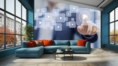 Video on demand technology with person touching play button on virtual screen to watch online VOD streaming of movie or TV Wall mural