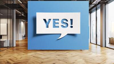 Yes sign showing positive answer, joy, agreement, celebration, affirmative decision or determination. Word yes on cutout paper speech buble on blue background. Wall mural