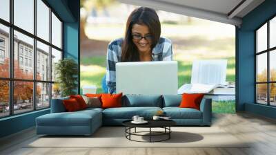 Laptop, lawn or happy woman in park with books for learning knowledge, information or education. Smile, textbook or female student on grass for studying history or typing online on college campus Wall mural