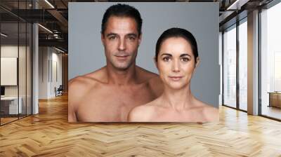 We care about our bodies. Studio portrait of a mature couple standing close together against a gray background. Wall mural