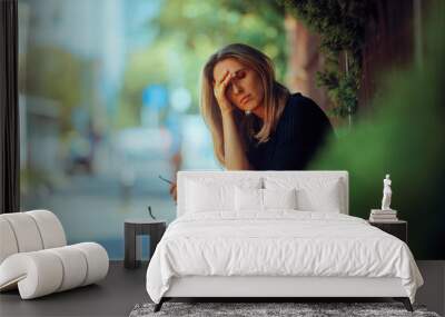 Stressed Woman Suffering a Headache Resting Outdoors. Tired adult person feeling unwell during a hot day
 Wall mural