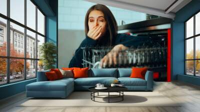 Woman having Problems with a Smelly Dishwashing Machine. Girl disliking the horrible smell coming from her kitchen appliance 
 Wall mural