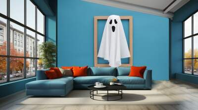 Minimalist ghost like draped white sheet on wooden frame, vibrant blue background contrasts simplicity Wall mural