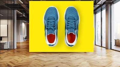 Blue sneakers close up top view. Sports shoes for running on a yellow background with copy space. The concept of jogging for a healthy lifestyle. Modern running shoes. Wall mural