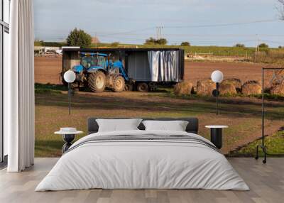 tractor and trailer working in a field Wall mural