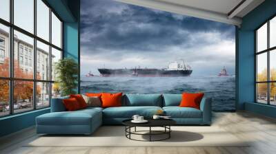 a tanker and tugboats on sea during a violent blizzard. Wall mural