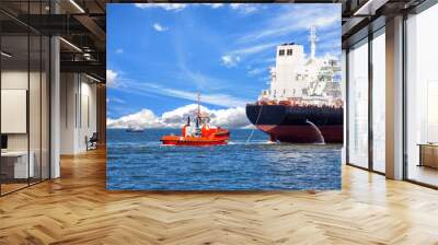 Tanker ship with escorting tug leaving port. Wall mural