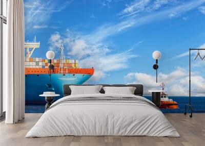 tugboat towing a large container ship on sea. Wall mural