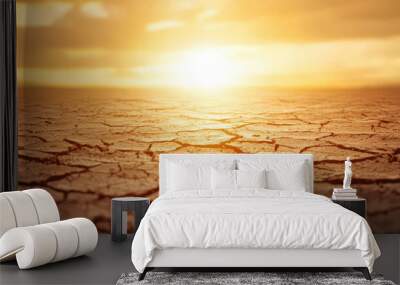 Desolate landscape at sunset with cracked earth, depicting climate change and drought effects in nature. Wall mural