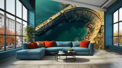 An old coastal city's enormous dam, which is situated where the land meets the sea, is the focal point of this aerial photo. Wall mural