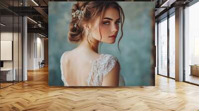 Beautiful bride-girl in an exquisite white dress with her shoulders open, seen from behind. Gorgeous woman poses by herself in an elegant bridal gown and jewelry. future bride. Cute bridal model Wall mural