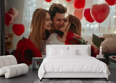 Beautiful young couple at home. Hugging, kissing and enjoying spending time together while celebrating Saint Valentine's Day with red roses on bed and air balloons in shape of heart on the background Wall mural