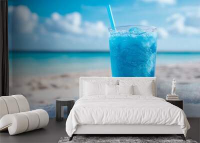 Glass of blue slush ice drink with a backdrop of a seashore Wall mural