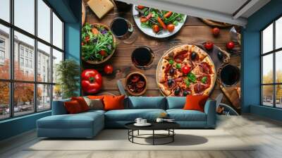 Pizza party dinner. Flat-lay of various kinds of Italian pizza, salad and red wine in glasses over rustic wooden table, top view, wide composition. Fast food lunch, celebration, gathering concept Wall mural