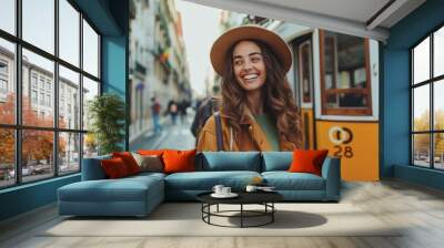 Smiling young traveler woman in Lisbon, exploring Portugal.Having fun on Europe trip.Tourist in front of famous 28 tram.Photographer blogger discovering european cities Wall mural