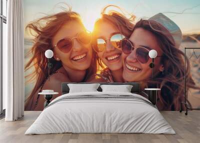 Three beautiful girls on the beach at sunset. Vacation time laughing and smiling Wall mural