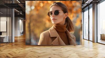 Young elegant fashionable woman in camel-colored coat, trendy sunglasses, and turtleneck in outdoor autumn portrait  Wall mural