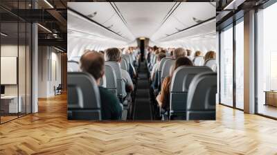 A crowded airplane with people sitting in the seats Wall mural