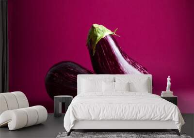 ripe eggplants over magenta background Wall mural