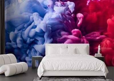 Splash of blue and pink paint in water over white background Wall mural