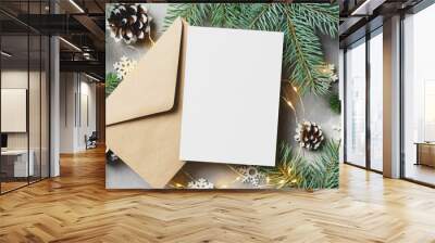 Christmas or New Year greeting card mockup with envelope, fir tree branches with cones and lighting garlands Wall mural