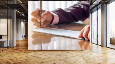 Business man hand writing and signing checkbook on the wooden table at office. Paycheck or payment by cheque concept. Wall mural