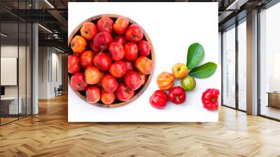 Closeup fresh small red organic  acerola cherry fruit (Malpighia Glabra) with green leaf in wooden bowl isolated on white background. Wall mural