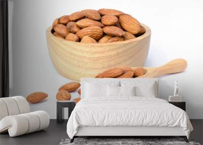 Closeup raw brown Almond seeds in wooden bowl and scoop isolated on white background.  Wall mural