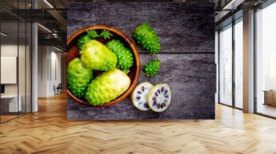 Fresh raw and ripe Morinda citrifolia or Noni fruit and sliced with seeds in wooden bowl isolated on white background. Wall mural