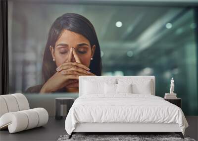 Feeling drained from all her efforts. Shot of a young businesswoman looking stressed out while working in an office. Wall mural