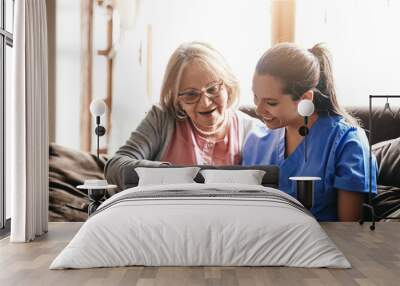 I have so many stories in here. a nurse and a senior woman looking at a photo album together. Wall mural