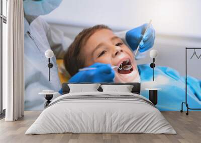 Im going to have a bright smile after this. Shot of a young little boy lying down on a dentist chair while getting a checkup from the dentist. Wall mural