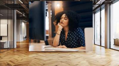 Starting to lose my focus. Shot of a young tired looking female designer falling asleep behind her computer at the office during the day. Wall mural