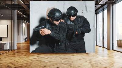 Two special forces soldiers covering each other and aiming with guns. Wall mural