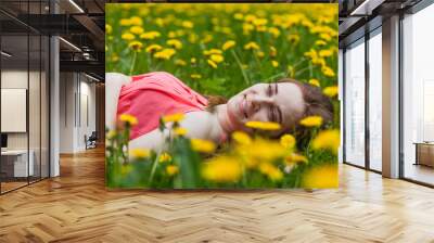 beautiful girl lying on the field of dandelions Wall mural