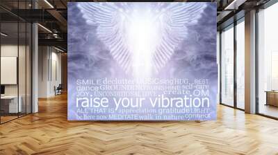 Angelic healing words to help raise your vibration - pair of angel wings hovering above a word cloud relevant to spirituality and raising your vibration, against a flowing energy background  Wall mural