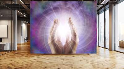 Reiki Master Healer sensing awesome vortexing energy field - male cupped hands reaching into a spiralling pink energy field with bright star orb between and copy space for message
 Wall mural