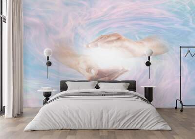 Working with Powerful Divine Energy - male hands emerging from blue pink rotating energy field background with bright white light energy between hands Wall mural