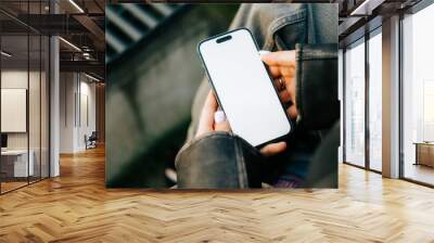 Woman using mobile phone outdoor with a white screen mock up . Wall mural