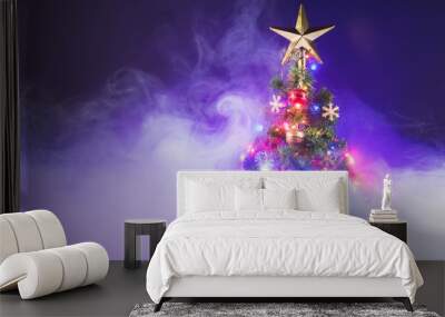 Christmas tree with festive lights, purple background with smoke Wall mural