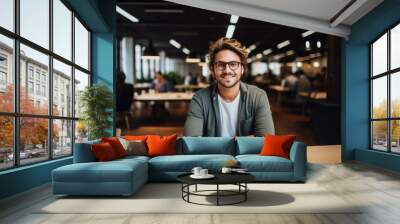 Smiling portrait of a happy young caucasian man working for a modern startup company in a business office Wall mural