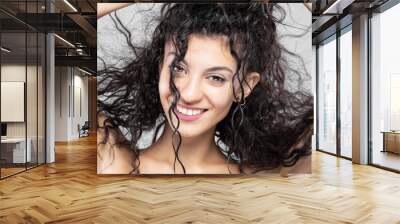 Beautiful brunette girl with long wet hair, studio portrait. Very happy smiling expression. Wall mural