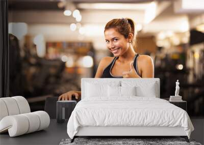 happy girl making thumbs up in a fitness club Wall mural