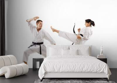 karate girl and boy fighting against white background Wall mural