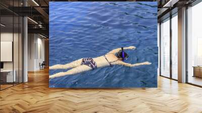 Snorkelling. Girl swimming in the sea with masks Wall mural