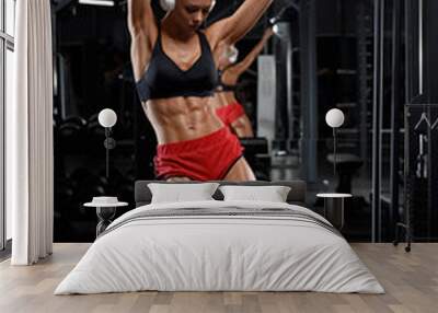 Fitness woman with abs in gym. Athletic girl working out Wall mural