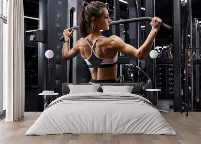 Fitness woman working out in gym doing exercise for back. Athletic girl doing lat pulldown Wall mural