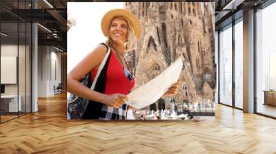 Traveler girl in Barcelona in front of Sagrada Familia. Woman tourist hold and look map, concept adventure Wall mural