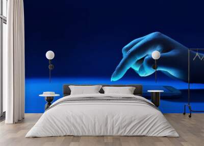 Female hand touching the screen of phone in dark blue environment Wall mural