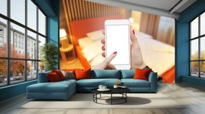 Smartphone mockup in female hand in bedroom, searching online Wall mural